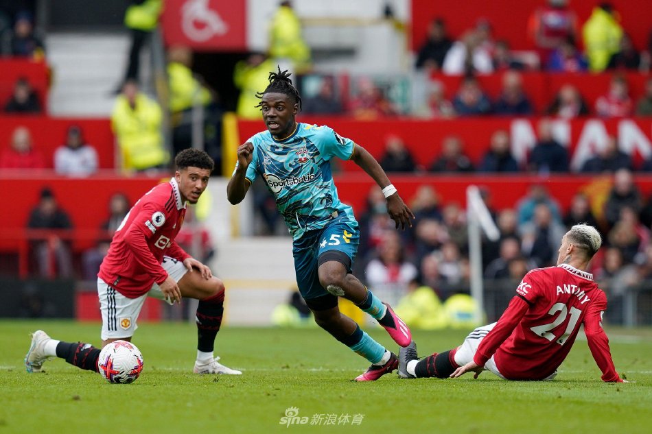 拉维亚与切尔西高层在签约桌前亲切握手，背景是俱乐部荣誉墙，象征信任与托付