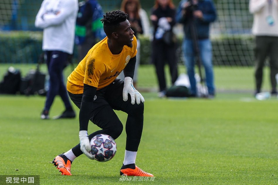 因扎吉教练手持战术板全神贯注讲解，队员们围聚聆听，阳光将他们的身影拉长在绿茵场上，构成一幅充满谋略与专注的备战图景。