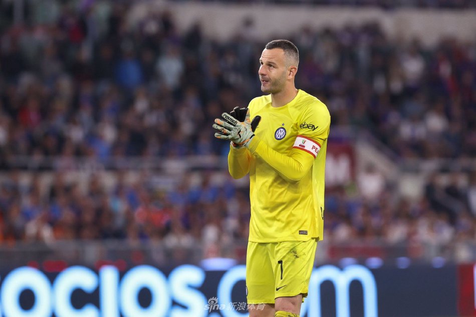 夕阳下的训练场，汉达诺维奇完成最后一次扑救练习，身影被拉长，象征着一段伟大职业生涯的落幕与传承。