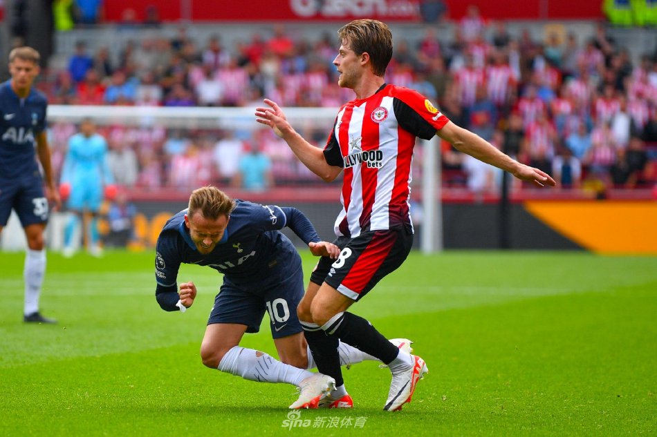 热刺球员埃莫森打入世界波扳平比分后张开双臂奔跑庆祝，身后是欣喜若狂的客队球迷和略显失落的布伦特福德后卫。