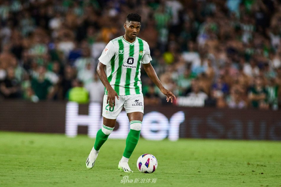 皇家贝蒂斯核心伊斯科在对方两名防守球员的包夹中轻盈转身护住皮球，他冷静的表情与优雅的控球姿态，与周遭激烈的对抗环境形成鲜明对比，仿佛绿茵场上的舞者，掌控着比赛的呼吸与节奏。