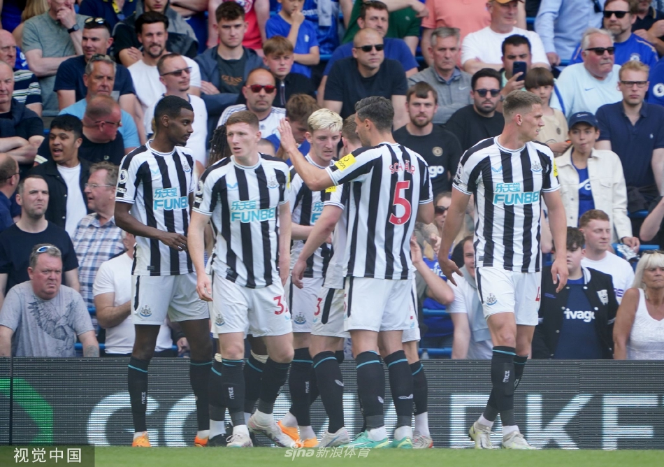 切尔西球员围拢在一起相互鼓劲，背景中可以看到看台上失望的纽卡斯尔联队球迷。