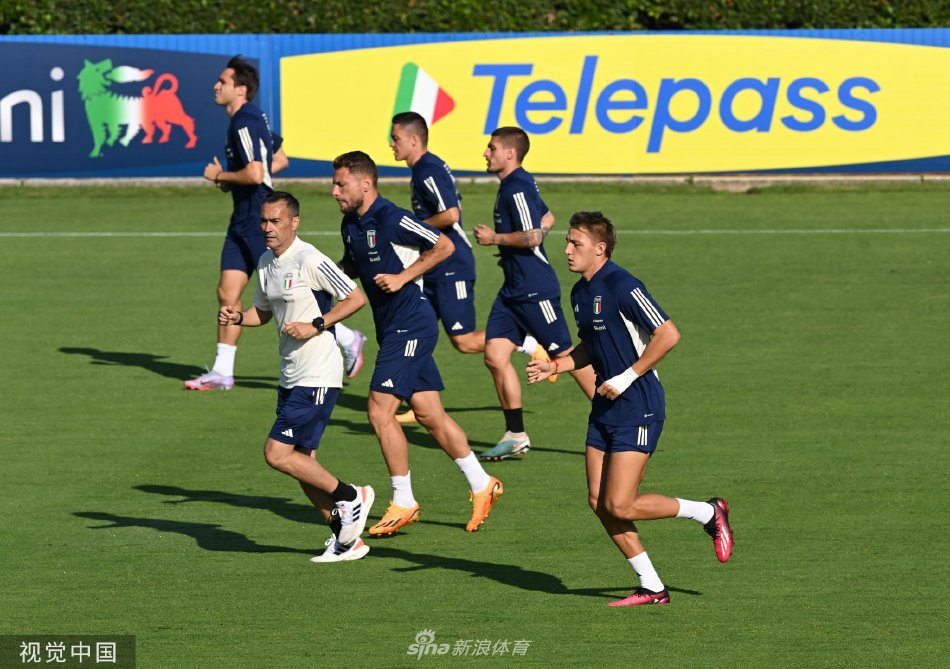 意大利全队围聚在训练场中圈，主教练曼奇尼正在向球员们进行细致的战术讲解，所有人神情专注。