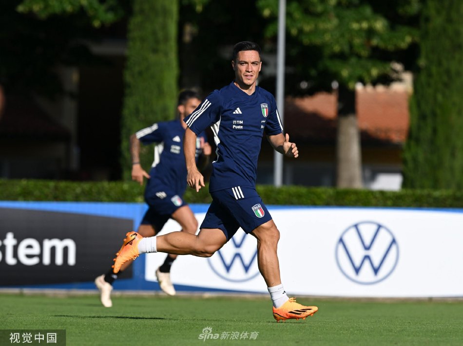 曼奇尼与助理教练站在场边，手持战术板，神情严肃地观察着训练赛的局势，并随时准备进行指导。