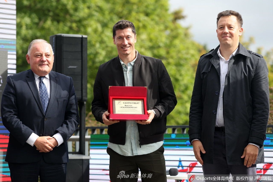 莱万俯身轻触自己刚留下的脚印，神情专注而肃穆，仿佛在与过去的奋斗历程对话，脚下的每一道纹路都记录着他在绿茵场上的每一次冲刺与射门。