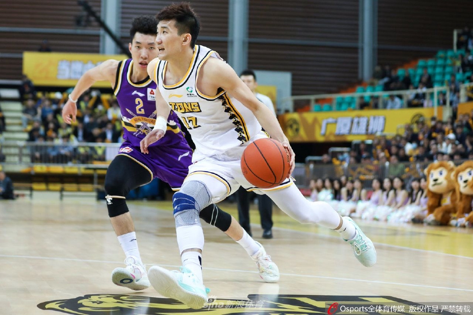 浙江东阳光外援威尔斯在比赛中眼观六路，高高跃起试图将球传给篮下的队友胡金秋，北控防守球员如临大敌，纷纷伸手干扰。