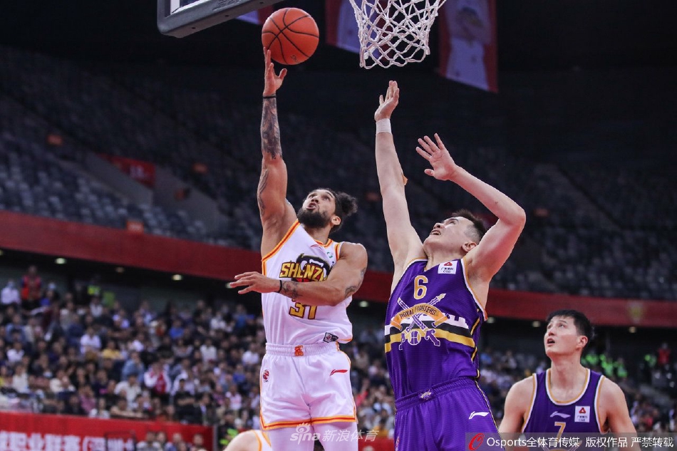 深圳队外援布克面对北控球员的贴身紧逼，凭借华丽的运球技巧寻找突破空间，眼神中透露着冷静与杀机