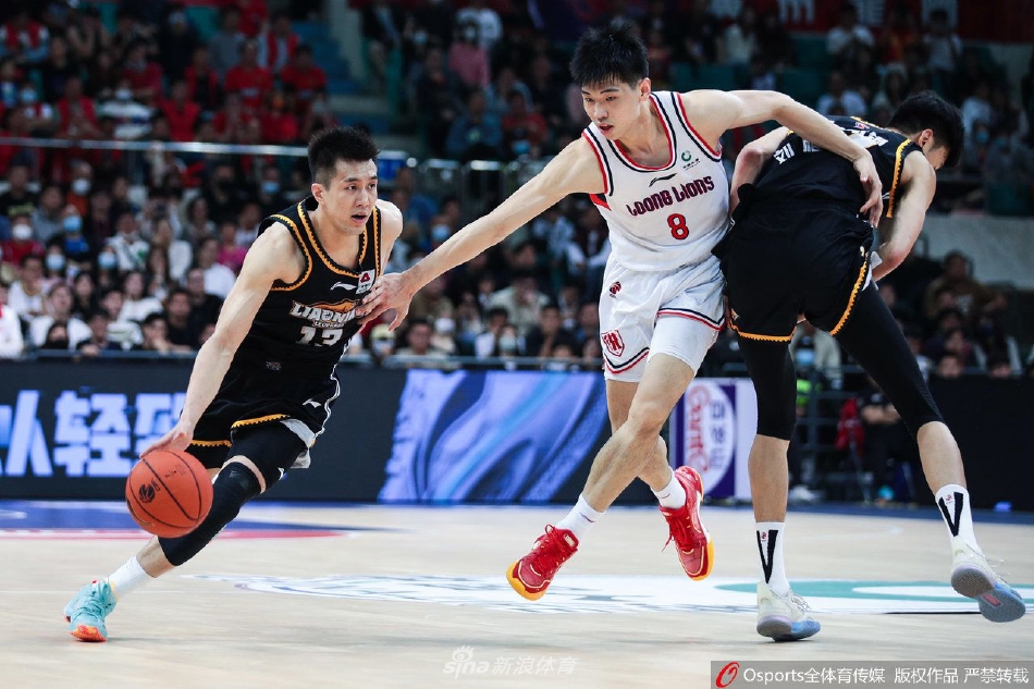 广州龙狮队球员崔永熙在辽宁本钢队球员的严密防守下，依然自信地跳起投篮，皮球在空中划出一道美丽的弧线。