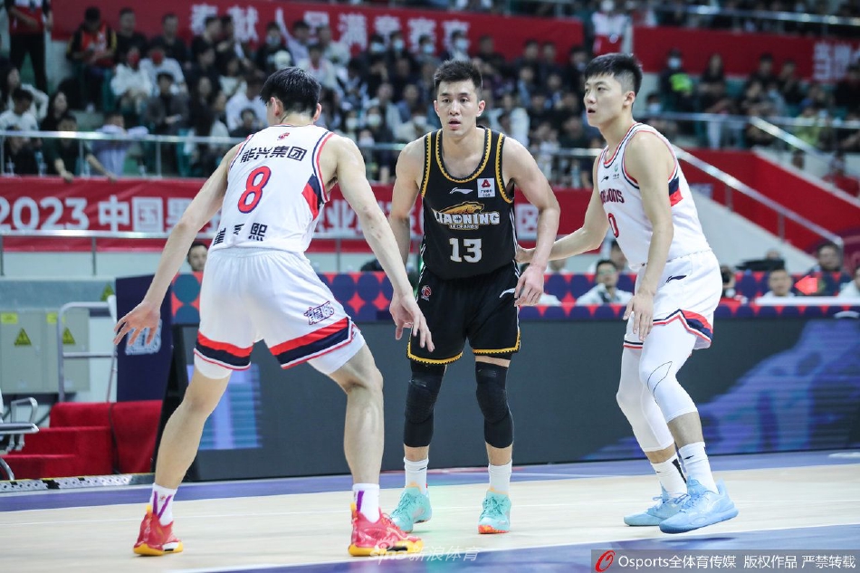 广州龙狮队球员李炎哲在辽宁本钢队的内线高高跃起，完成一记势大力沉的单手灌篮，展现了年轻内线的霸气。