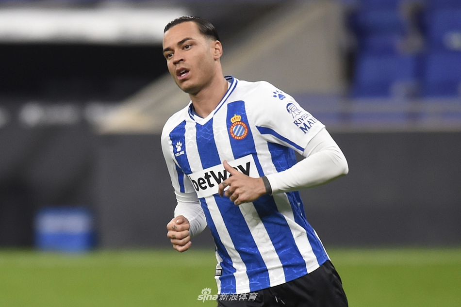 武磊替补登场后积极跑动回防，他在边路奋力追赶对方进攻球员，眼神专注，全身肌肉紧绷，展现出强烈的求战欲望。