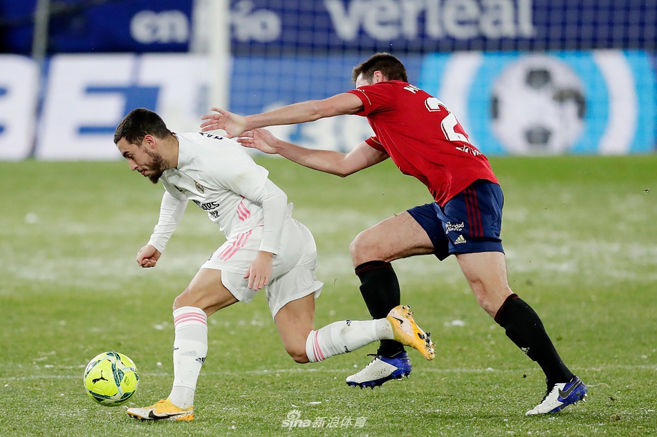 本泽马在射门瞬间被对方后卫飞身封堵，两人在积雪的草皮上激烈碰撞，溅起一片白色的雪花，完美诠释了这场比赛的艰难与胶着。