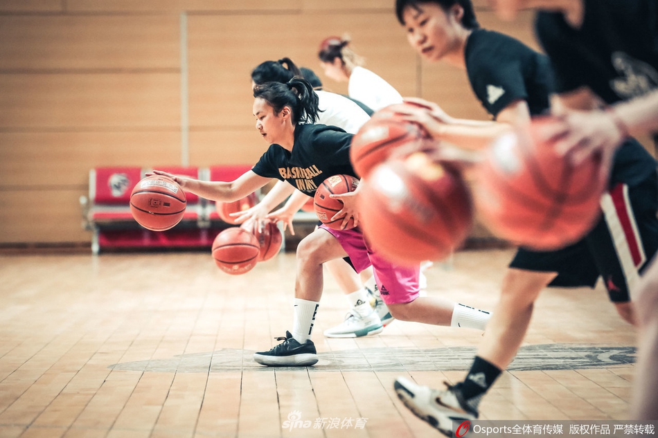 主教练在场边双手合十，神情严肃地注视着场内球员们的对抗训练，每一个细节都逃不过他的眼睛。