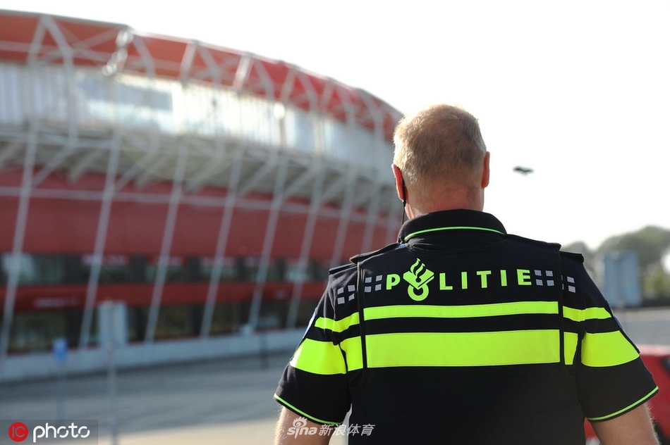 夕阳余晖下，被毁的看台显得格外寂静而悲凉，空无一人的座椅上散落着瓦砾，远处的广告牌依旧鲜艳，却与眼前的废墟形成鲜明对比。