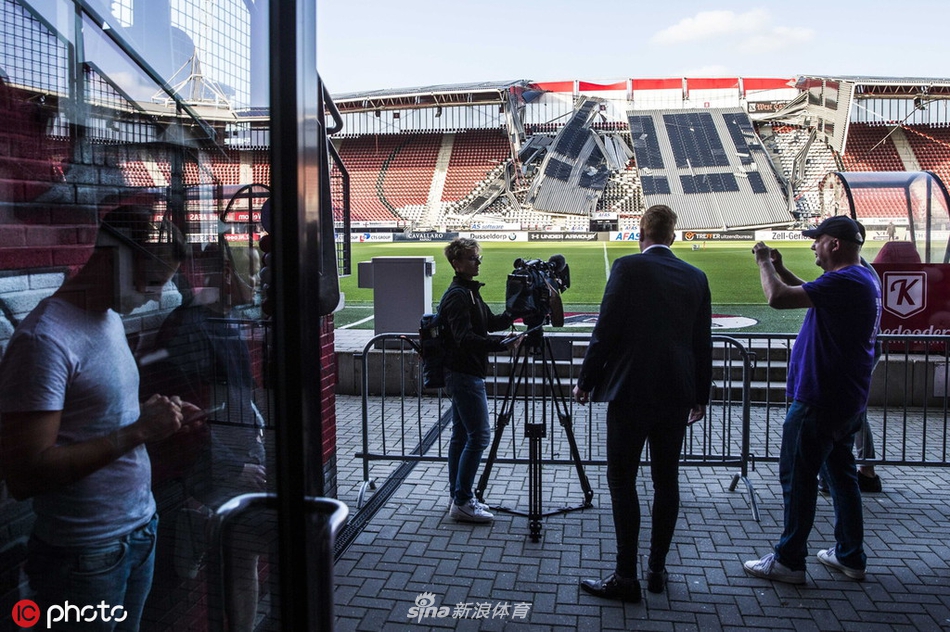 近处断裂的混凝土预制板边缘参差不齐，下方原本供球迷站立助威的台阶上，如今堆满了瓦砾和扭曲变形的金属支架。