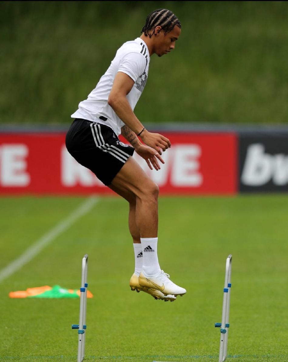 在激烈的对抗中，萨内用身体护住皮球，他的脏辫发型显得格外有型，这不仅是他的个性标签，更象征着他在球场上那种不羁的创造力和求胜欲。