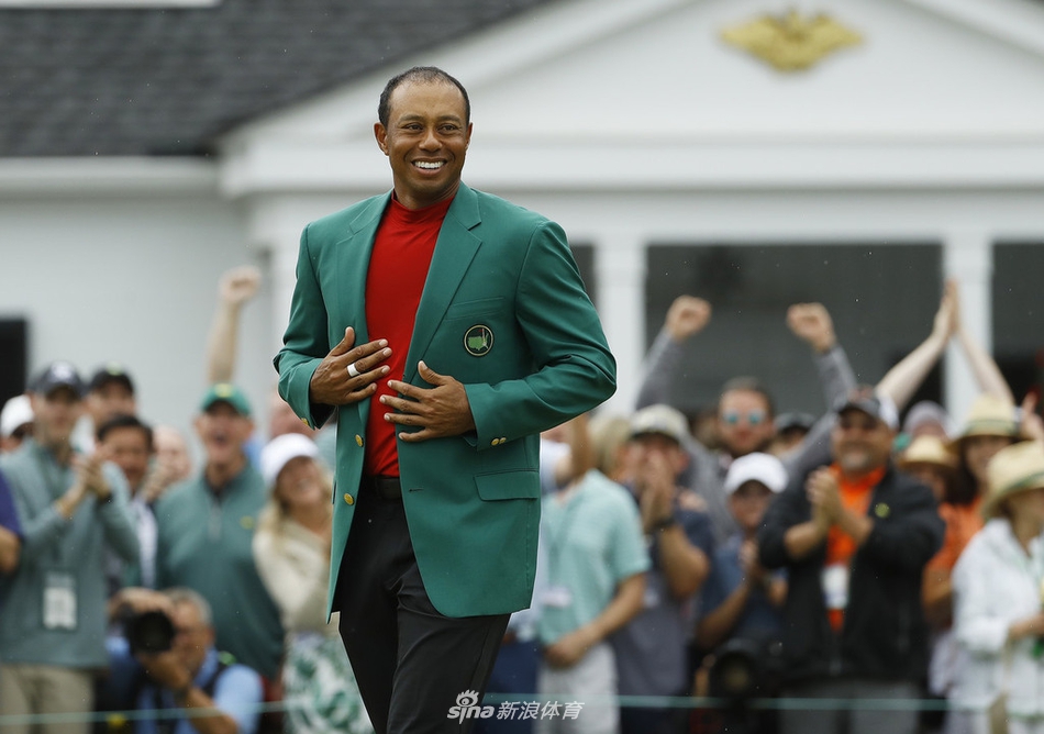 伍兹在果岭旁单膝跪地，与飞奔而来的儿子查理深情拥抱，父爱满溢