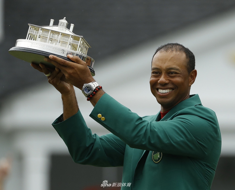 在奥古斯塔会馆，上届冠军帕特里克·里德为伍兹穿上第五件绿夹克，伍兹脸上洋溢着满足与自豪的笑容