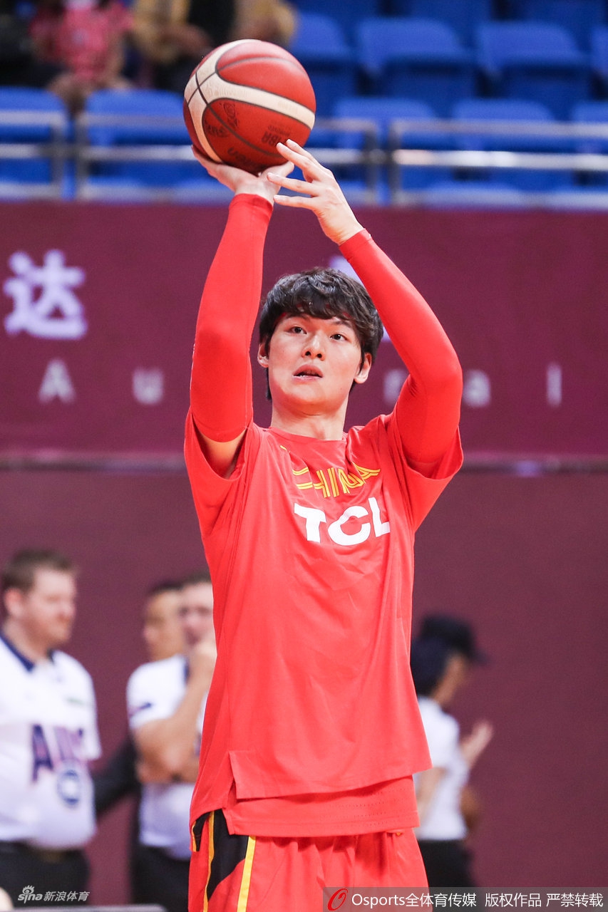 郭艾伦完成一次投篮后自信地握拳，眼神坚毅地望向篮筐，对即将到来的比赛充满了战斗的渴望。