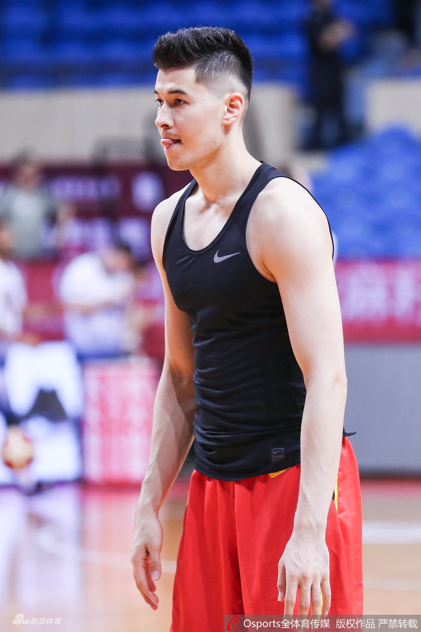 郭艾伦与队友在热身时轻松交流，脸上带着标志性的自信微笑，似乎在分享着彼此对比赛的见解。