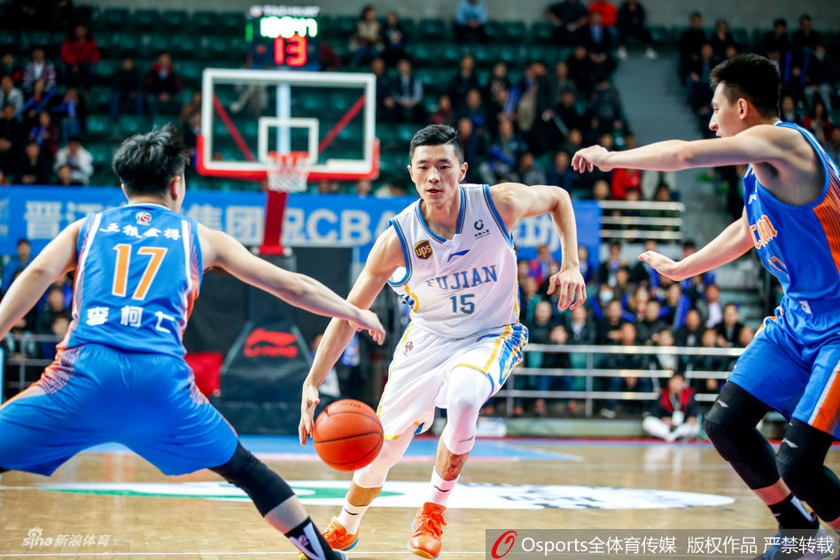 王哲林中距离跳投出手，眼神坚毅，四川队的汤普森奋力起伸手臂封盖