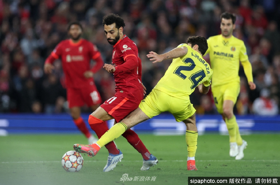 利物浦教练克洛普在场边振臂欢呼，背景是萨拉赫与马内拥抱庆祝进球的背影，完美诠释了团队胜利的喜悦