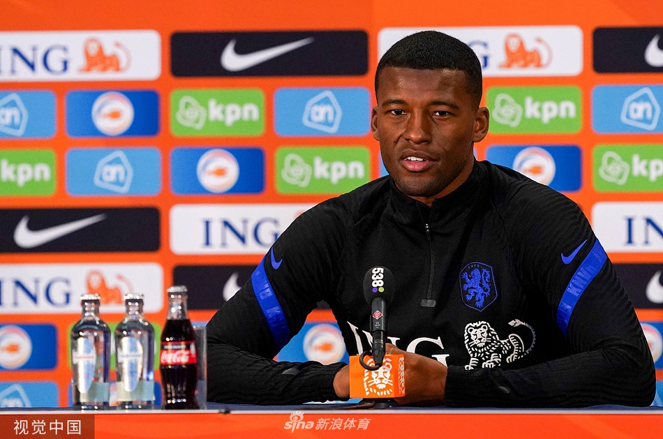 队长与德波尔并肩而坐，面对密密麻麻的采访话筒，他嘴角带着一丝自信的微笑，从容不迫地应对每一个犀利提问，肩上的队长袖标象征着责任与领导力。