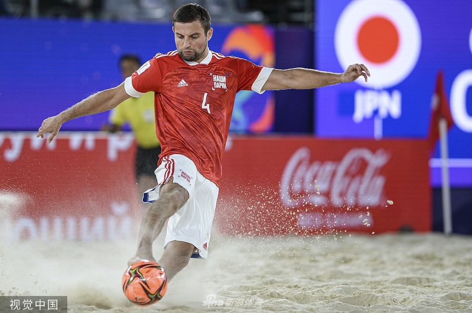 东道主俄罗斯队球员在漫天黄沙中拔腿怒射，皮球带着旋转飞向球门，展现出沙皇军团的强大气场。