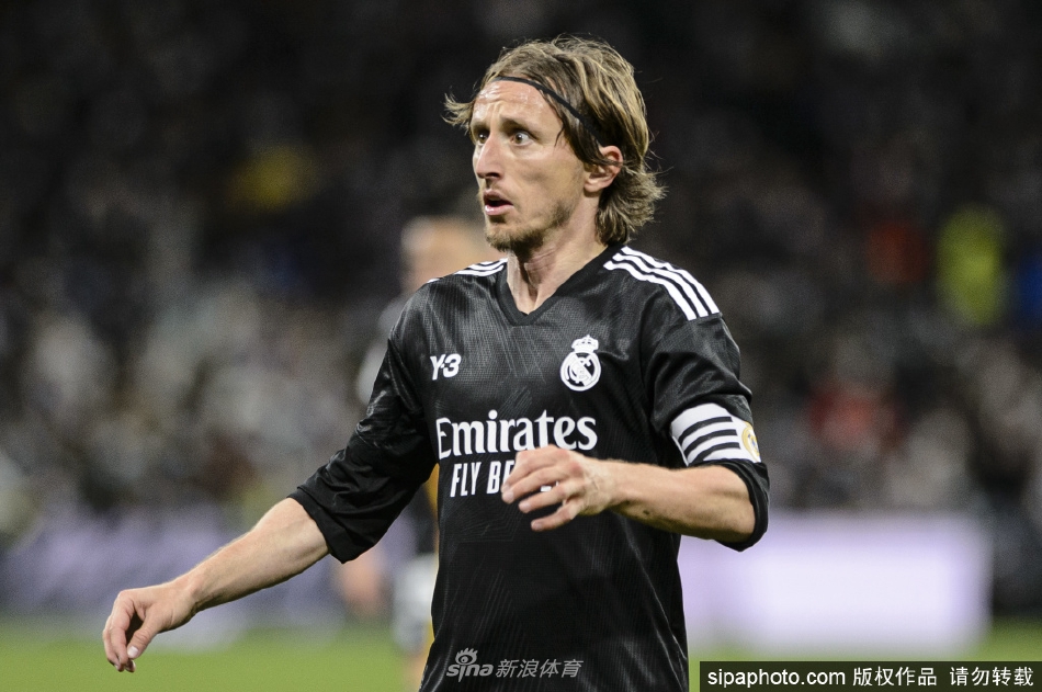 莫德里奇与队友在进球后激情相拥庆祝，他张开双臂，笑容灿烂，完美诠释了团队胜利的喜悦与足球运动的纯粹激情。