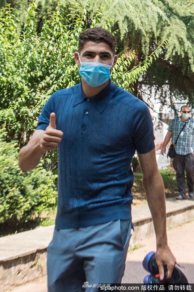 在诊所明亮的走廊里，阿什拉夫换上了国际米兰的白色训练上衣，正准备进行体检。他微微侧身，胸前的队徽清晰可见，年轻的身体蕴含着惊人的爆发力，这一刻，他与蓝黑色的联系变得真实而具体。