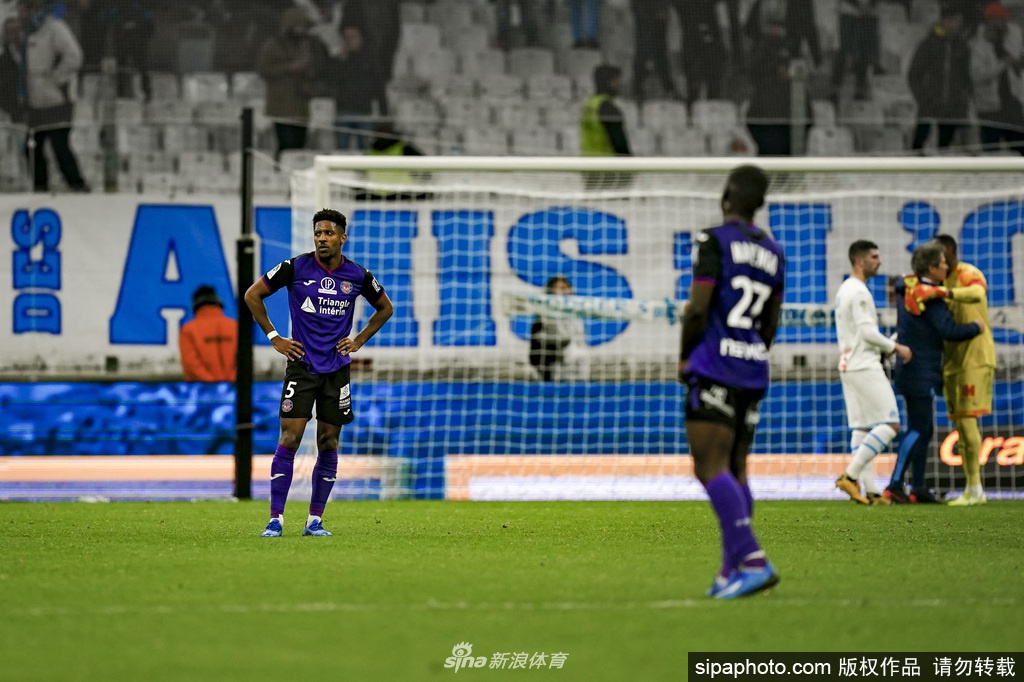 晨曦中的图卢兹市政厅广场，一名穿着老款图卢兹球衣的孩子正在踢球，足球腾空而起的瞬间，远处的圣塞尔南大教堂钟楼轮廓清晰，象征着这座城市的足球血脉从未中断。