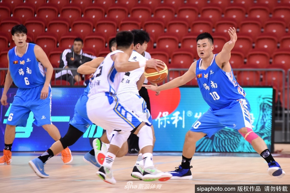 海南海象球员在三人包夹下高高跃起拼抢篮板,肌肉线条紧绷,眼神坚毅充满不甘与斗志。