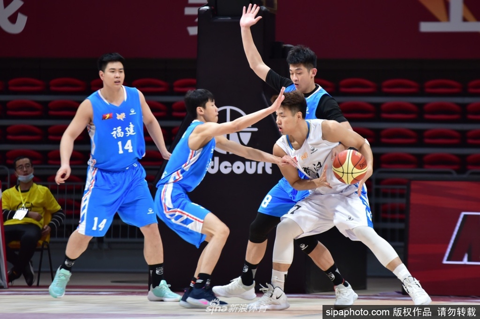 福建莆田兴发队球员在外线持球准备进攻,眼前是武汉当代队员张开双臂的严密防守,双方球员站位紧凑,场上气氛紧张。