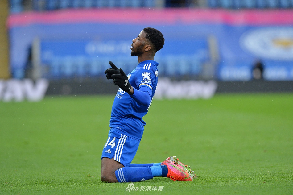 瓦尔迪在边路奋力倒地铲球传中，眼神专注，草屑飞溅，为队友送出了决定性的助攻