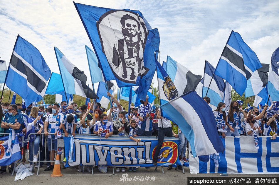 几名西班牙人球员在敞篷大巴上，与看台上的球迷互动，共同展示着象征升级的横幅，场面热烈感人。