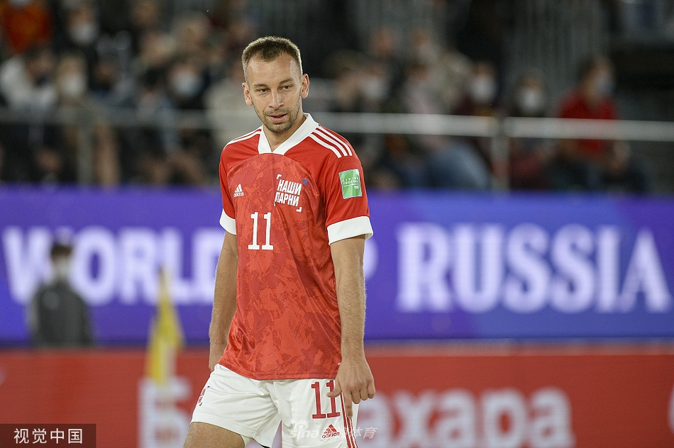 日本队教练组成员在场边激动指挥，表情投入，汗水浸湿了衣衫，身后是紧张观战的替补球员和助威的俄罗斯球迷。