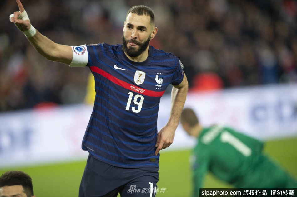 本泽马身着优雅西装，在摄影棚内专注于拍摄《法国足球》杂志封面，目光坚定而深邃