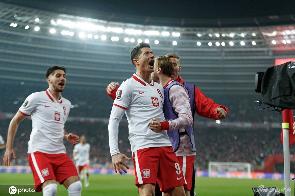 波兰全队赛后紧紧相拥庆祝，队长莱万振臂高呼，身后是陷入狂欢的绿色海洋。