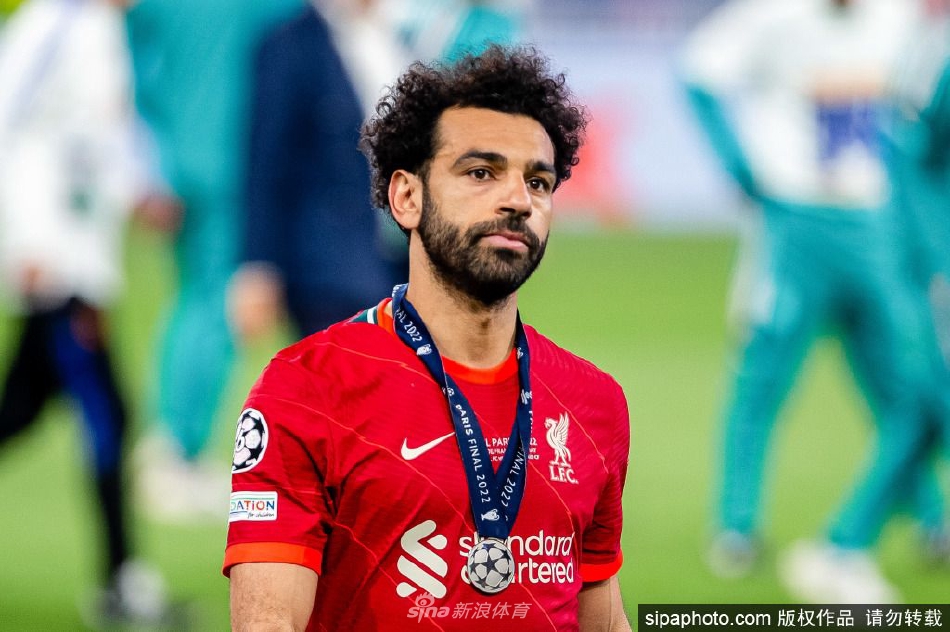 利物浦前锋萨拉赫在安菲尔德球场专注比赛，眼神坚定如炬。