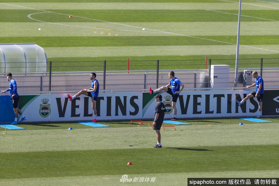 完成一组训练后，两名沙尔克04球员隔着数米远进行简短的交流。他们脸上带着笑意，但都理智地没有走近对方，身后是空荡荡的看台，这一幕成为疫情时期足坛的独特记忆。