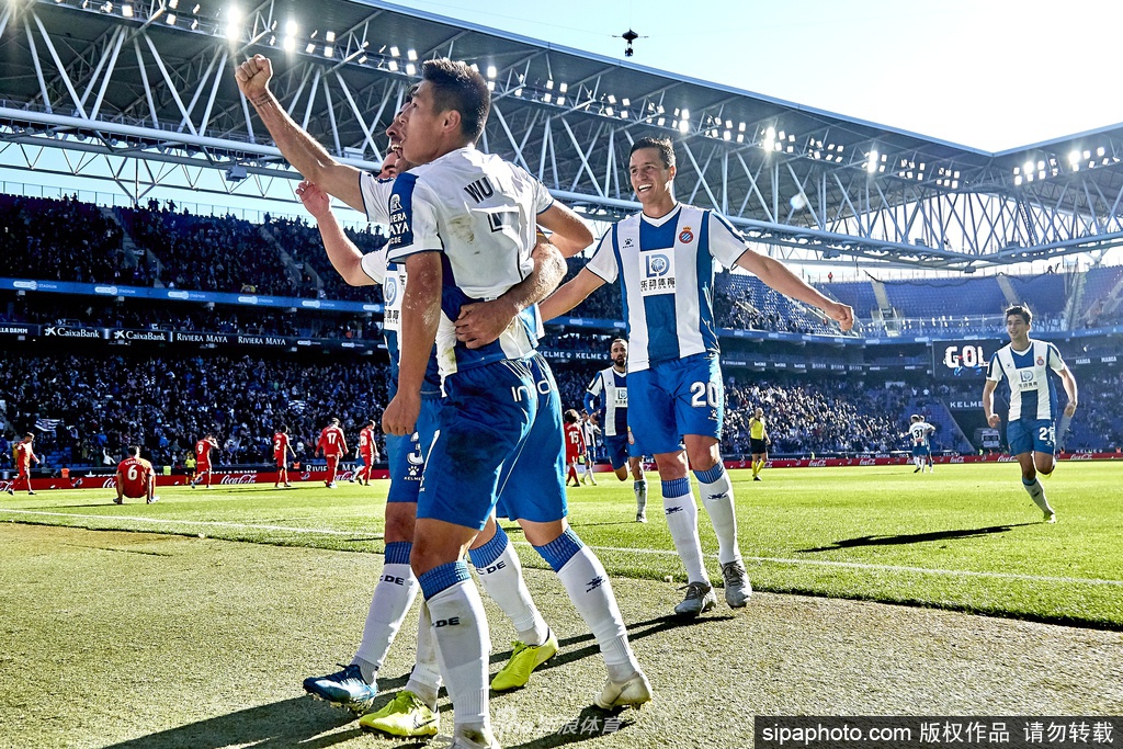 一名队医正为球员认真地进行体温测量，身后的医疗桌上整齐摆放着检测设备和防护用品，为复训筑起第一道安全防线。