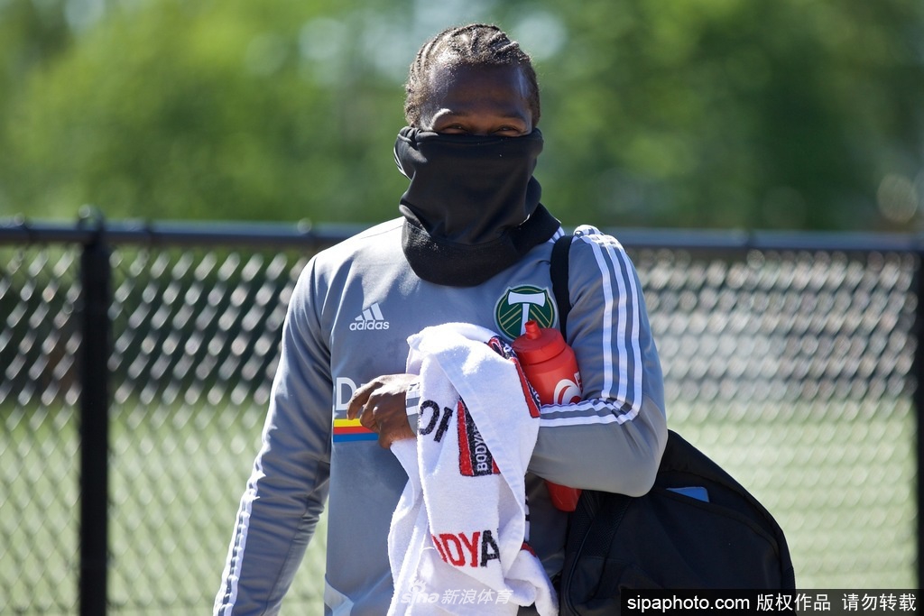 夕阳下的守望：训练结束，一名球员独自走向场边，他的身影被夕阳拉长。身后的足球静静地停在草地上，远处的波特兰天际线依稀可见。这一刻，训练场恢复了寂静，但明天，这里将继续成为希望重启的地方。