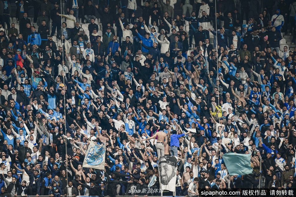 体育场外的球迷商店里，工作人员正在整理货架上的新赛季球衣，门口的玻璃上贴着感谢萨德朗的海报，零星有戴着口罩的市民驻足观看，日常的平静中隐藏着对未来的忐忑。