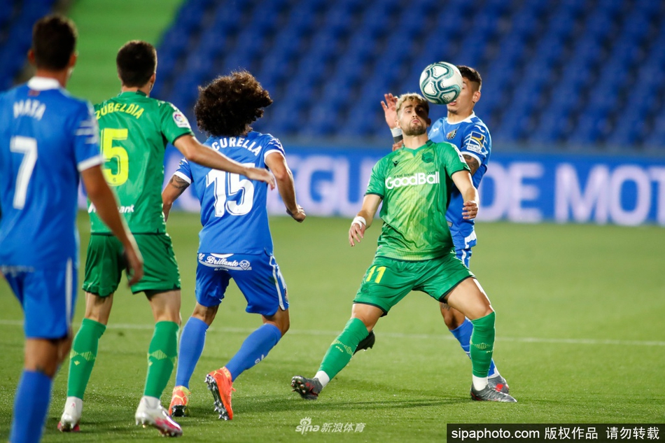 赫塔菲球员们相拥庆祝胜利，蓝色的球衣在灯光下熠熠生辉，团结一心