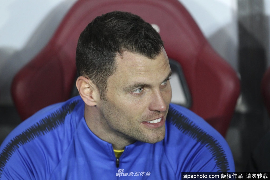 训练间隙，帕德利戴着标志性的守门员手套，与队友进行轻松地交流和讨论，阳光洒在他充满岁月痕迹但依旧坚毅的脸庞上。