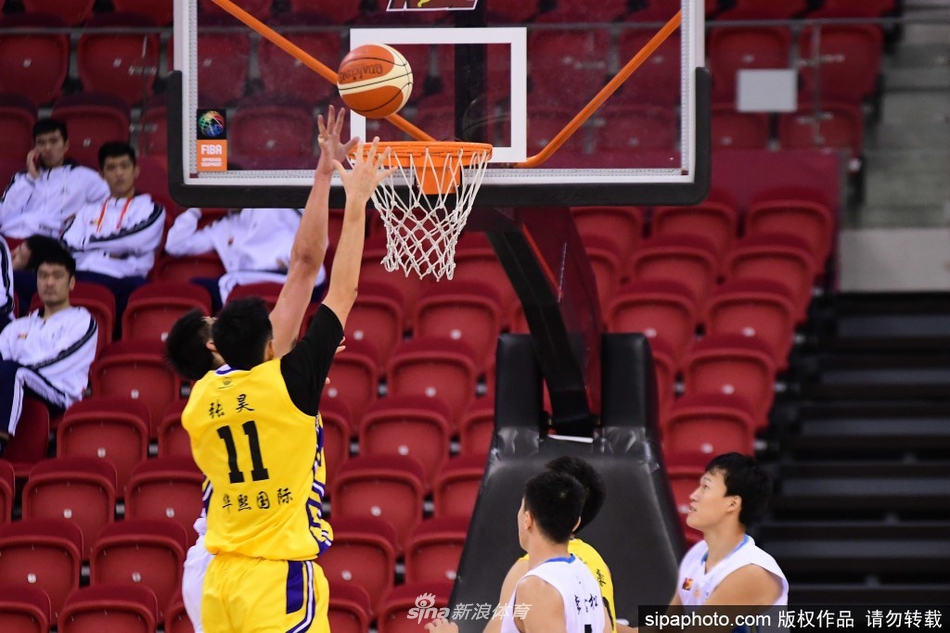 安徽文一球员在重庆华熙国际队员的严密防守下,依然自信出手,篮球在空中划出一道完美的弧线飞向篮筐。