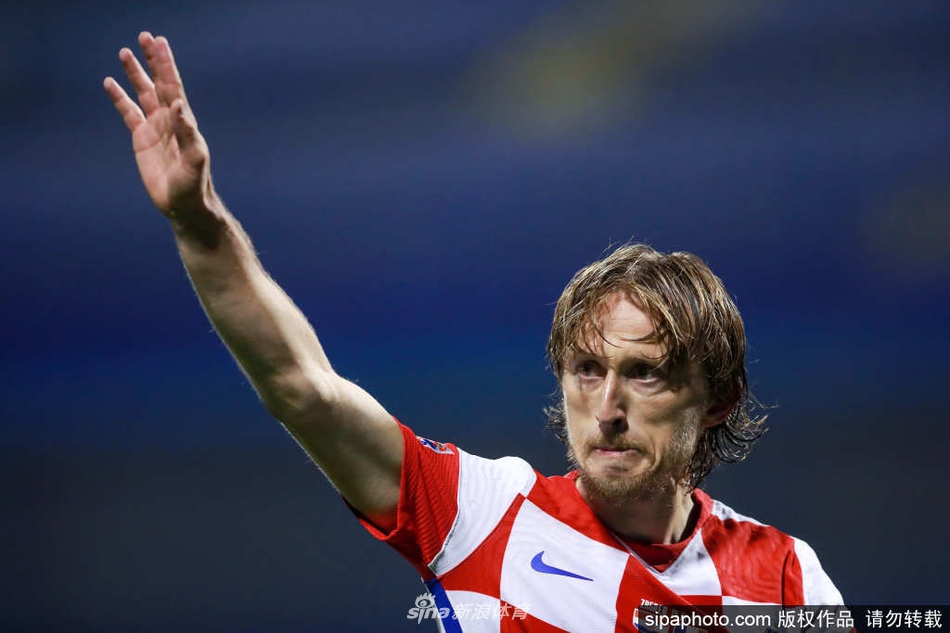 在斯普利特球场璀璨的灯光下，莫德里奇眼神坚毅，他身后的看台上，克罗地亚球迷拉起巨幅旗帜，仿佛在用整个国家的期待，托举起这位正在向历史纪录发起冲击的队魂。