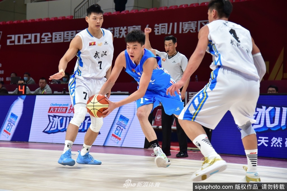 武汉当代队员在福建莆田兴发的内线群中高高跃起,抢下关键的进攻篮板,他强壮的身躯在对抗中占据明显优势,充满了力量感。