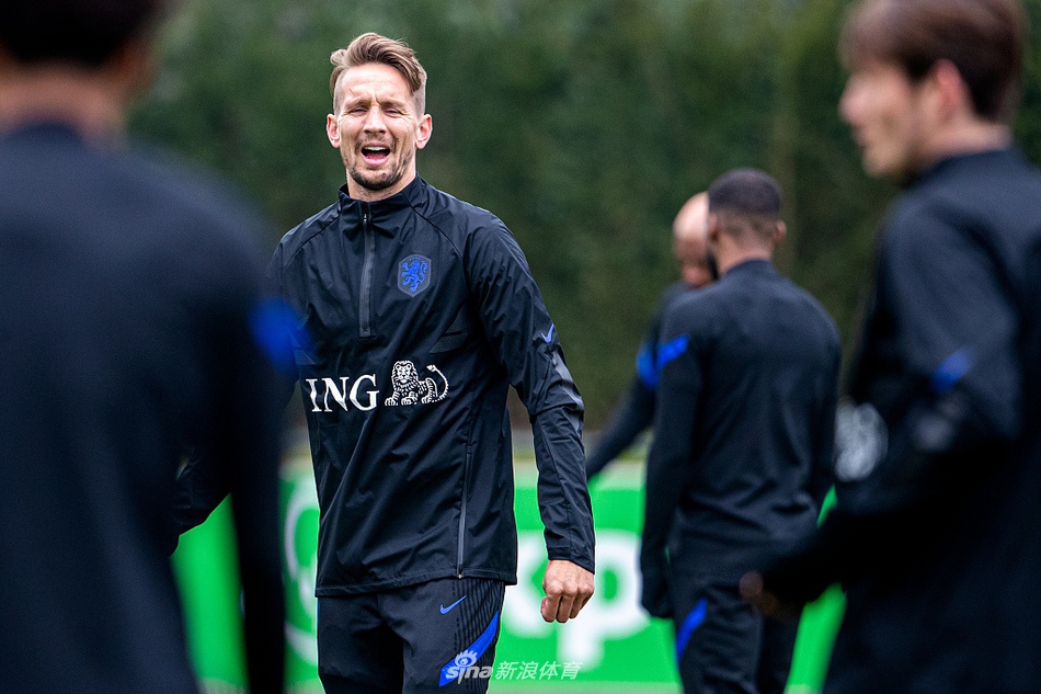 新闻发布会现场，弗兰克·德波尔面对镜头侃侃而谈，他用手势强调着战术要点，背景板上的队徽熠熠生辉