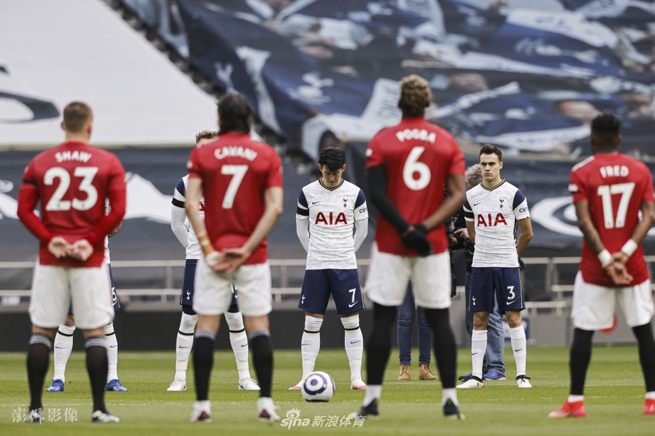 英超裁判组成员也加入默哀行列，他们与球员们并肩而立，手臂同样佩戴黑纱，背景中可见空荡荡的看台和悬挂的旗帜，画面充满仪式感