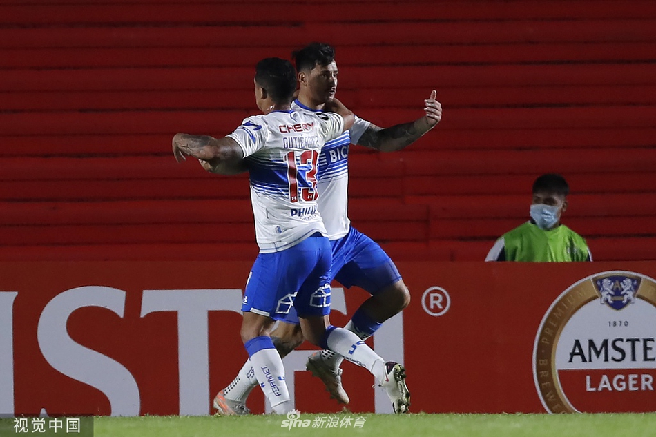 阿根廷青年人队的中场发动机在对方半场遭遇智利大学球员的严密包夹，他正奋力张开双臂护住皮球，眼神中透露出不屈与坚毅，脚下的足球仿佛成为他必须守护的圣物。